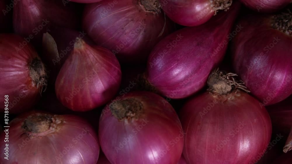 Rotating red onion emerge from the darkness into light. Pile of onions close up. 4K footage Rotating red onion emerge from the darkness into light. Pile of onions close up. 4K footage