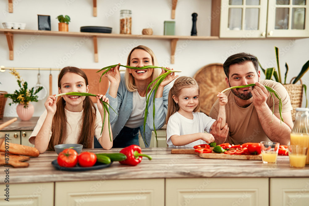 Happy family enjoying cooking together in the kitchen with fresh vegetables and laughter Happy family enjoying cooking together in the kitchen with fresh vegetables and laughter