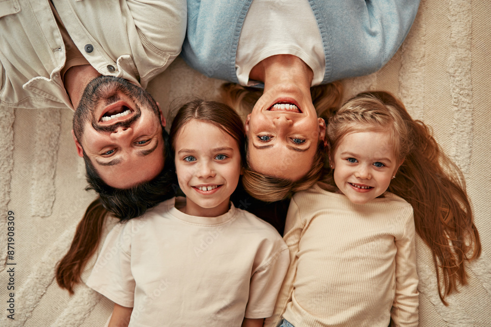 © Valerii Apetroaiei - A happy family is on the carpet, with smiling parents and children enjoying their time together © Valerii Apetroaiei - A happy family is on the carpet, with smiling parents and children enjoying their time together