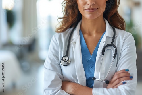 Confident female doctor with stethoscope, arms crossed, in hospital setting. Professional healthcare worker in medical uniform. photo