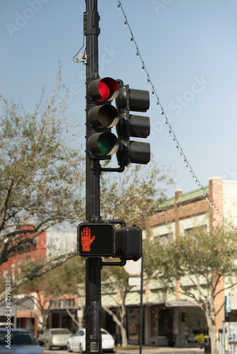 Red traffic light on a black pole in downtown area, verticle