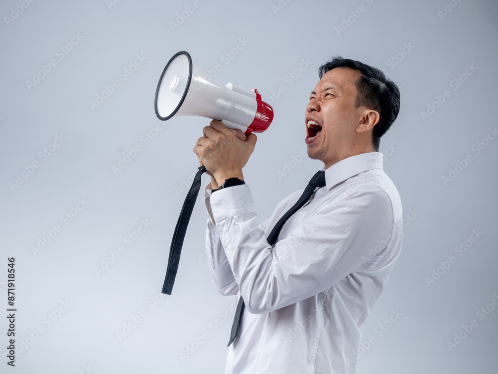 Asian businessman in white shirt and black tie enthusiastically holding a megaphone, speaking or announcing with a joyful expression, standing against a plain light background Asian businessman in white shirt and black tie enthusiastically holding a megaphone, speaking or announcing with a joyful expression, standing against a plain light background
