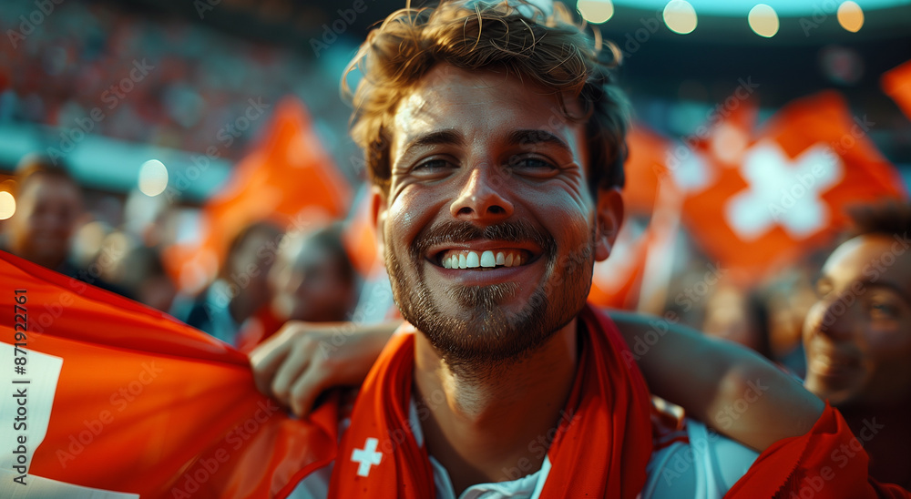 Portrait of handsome happy football fan on stadium surrounded with Switzerland flags. Portrait of handsome happy football fan on stadium surrounded with Switzerland flags.
