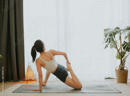 Asian girl doing yoga at home in a white background