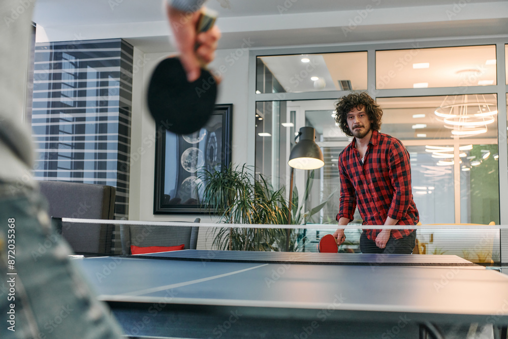 Obraz premium Business colleagues take a break from work to enjoy a game of table tennis, fostering teamwork and camaraderie in the workplace