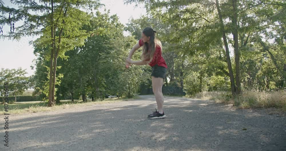 Girl stretching or warming up her full body before dance practice in a green sunny park. Girl stretching or warming up her full body before dance practice in a green sunny park.