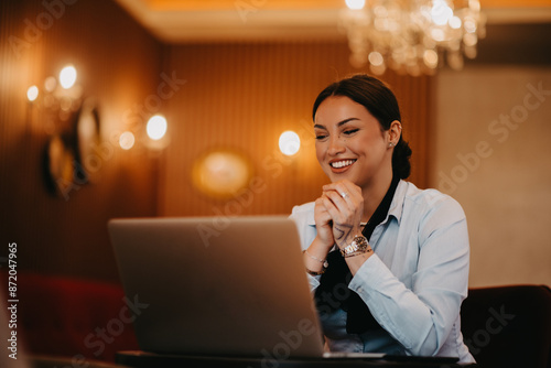 Radiant Latina businesswoman confidently leads business meeting over coffee.