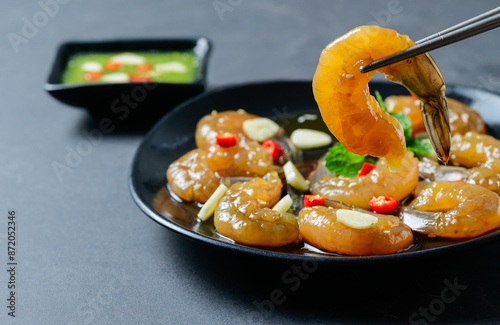 Pickled shrimp with chopstick Soy Sauce, chilli and garlic on stone background, photo