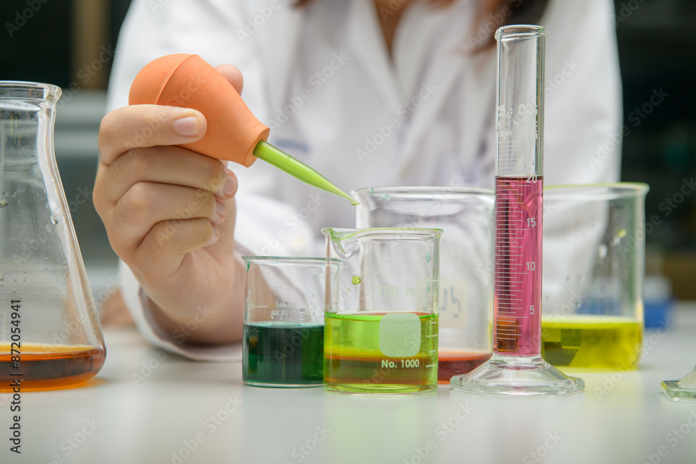girl scientist loads liquid sample into with plastic pipette. education and science girl scientist loads liquid sample into with plastic pipette. education and science