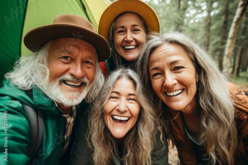 Portrait of smiling diverse senior friends in front of tent outdoors © Geber86