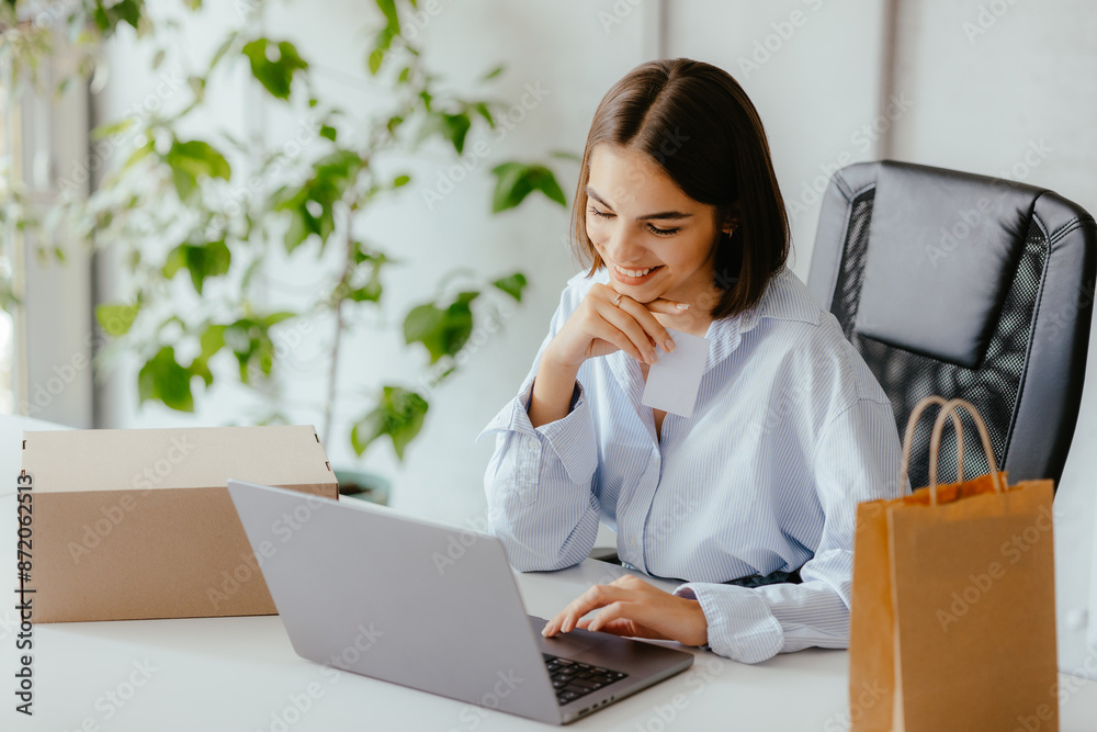 Woman Working on Laptop with Parcel Boxes and Shopping Bag Woman Working on Laptop with Parcel Boxes and Shopping Bag