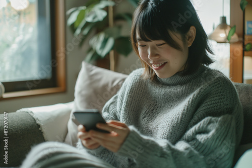 a Japanese Woman Using a Smartphone on a Sofa