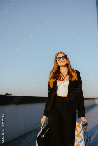 Stylish woman with shopping bags under blue sky © Sandu