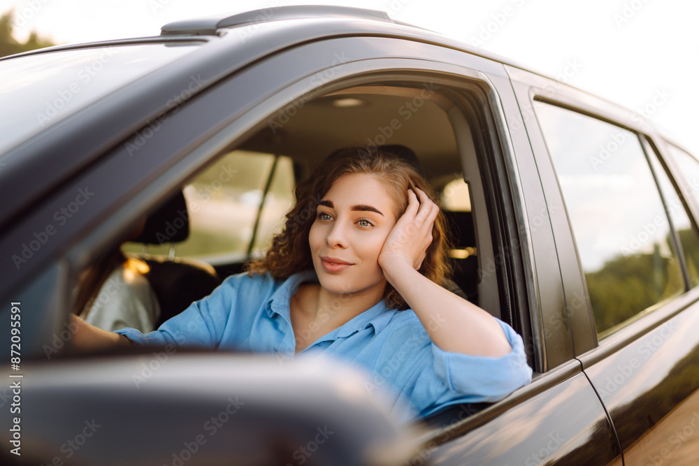 Two fun young women driving in a car in town laughing and smiling as they socialise together. Travel, tourism. Two fun young women driving in a car in town laughing and smiling as they socialise together. Travel, tourism.