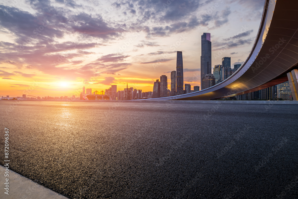 Obraz premium Asphalt highway road and bridge with modern city buildings scenery at sunset in Guangzhou. car advertising background.