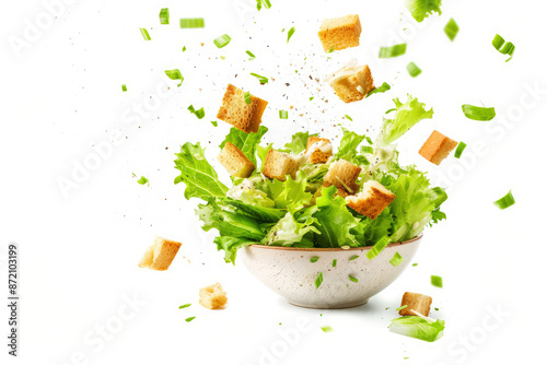 Obraz na płótnie Fresh Caesar salad with flying croutons and greenery, isolated on a white background, highlighting its gourmet appeal w salonie