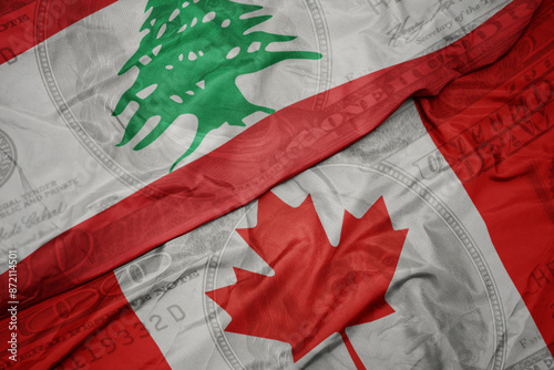 waving colorful flag of lebanon and national flag of canada on the dollar money background. finance concept. photo