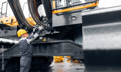 Фотография Professional mechanic diagnostics hydraulic hose system equipment on excavator to raise bucket