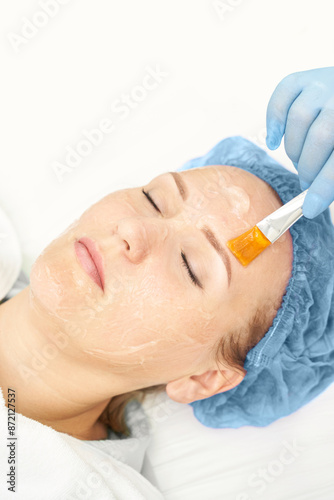 Dermatology anti age treatment. Applying gel with brush. Microcurrent medicine procedure. Woman skin care. Aesthetic peeling therapy. RF cosmetology at spa. Doctor hands in gloves. Wrinkle reduction photo