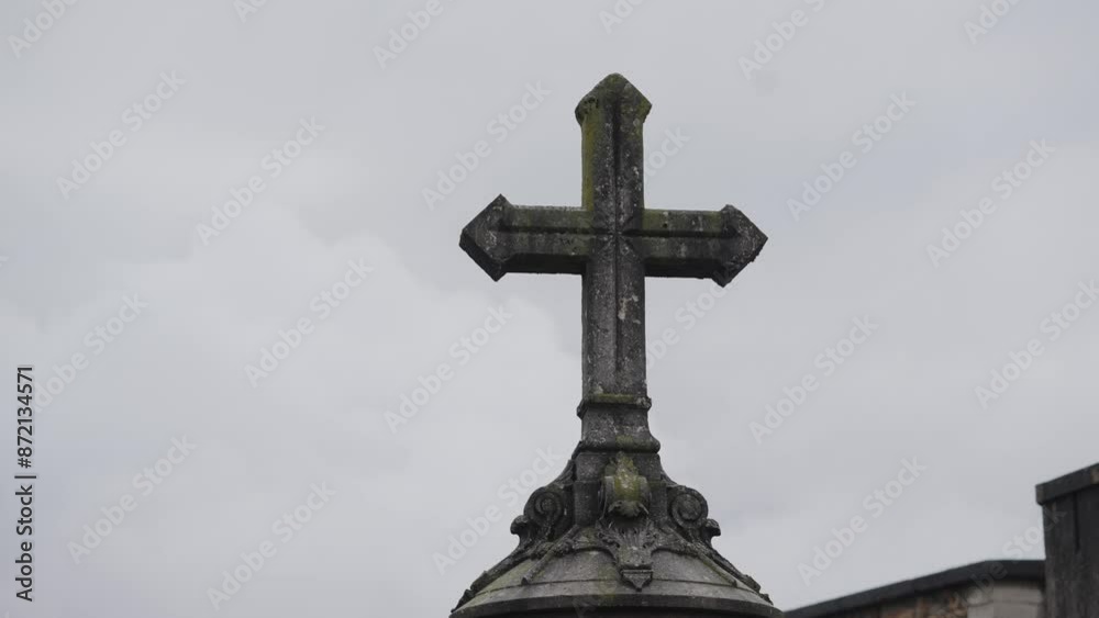 Beneath the cloudy sky, an ancient stone cross stands as a timeless symbol of faith Beneath the cloudy sky, an ancient stone cross stands as a timeless symbol of faith