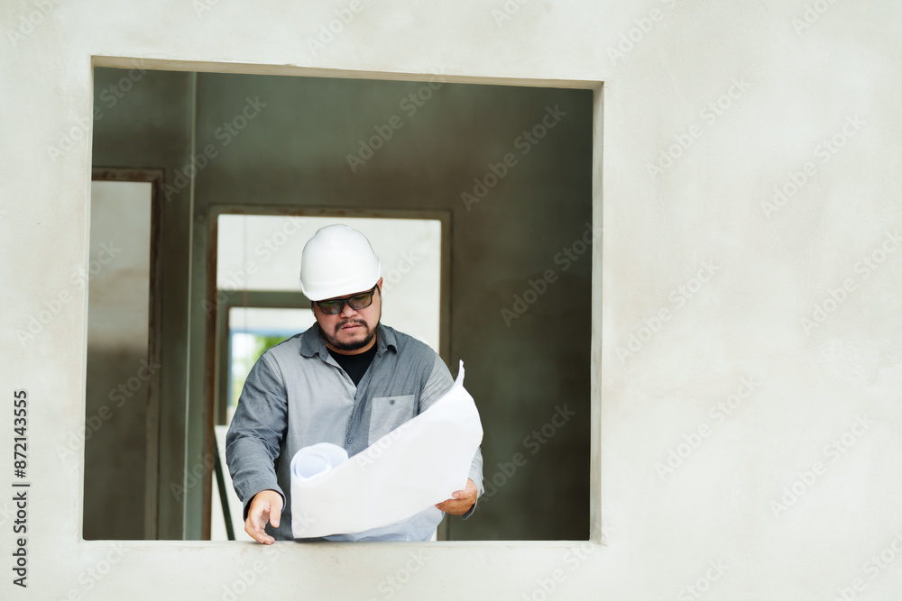 architect employee enginee designer manager foreman, Asian man Stand holding building model inspect house structure unfinished window sill. Wear white safety helmet protect yourself falling objects. architect employee enginee designer manager foreman, Asian man Stand holding building model inspect house structure unfinished window sill. Wear white safety helmet protect yourself falling objects.