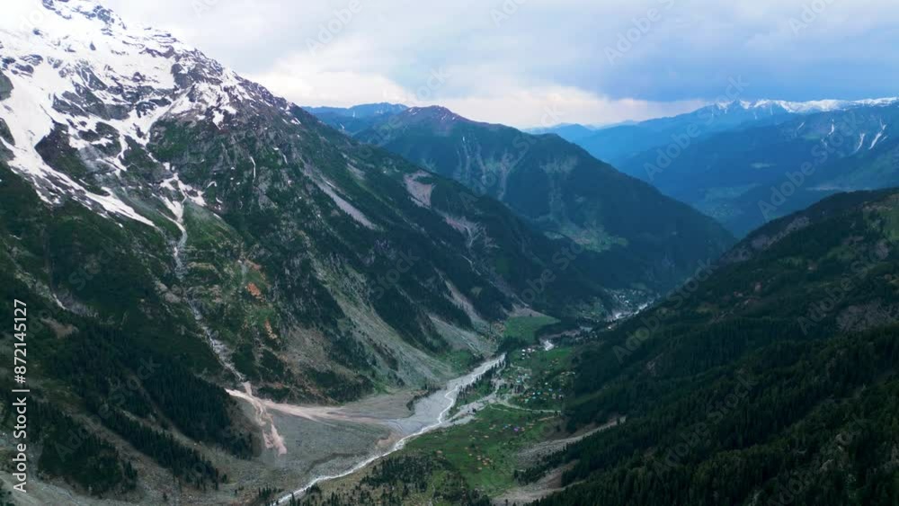 Aerial view of a small river in the middle of a green field and forest in the wilderness. Natural Resource and Ecosystem. Taip Meadows, Swat Valley, Pakistan. Aerial view of a small river in the middle of a green field and forest in the wilderness. Natural Resource and Ecosystem. Taip Meadows, Swat Valley, Pakistan.