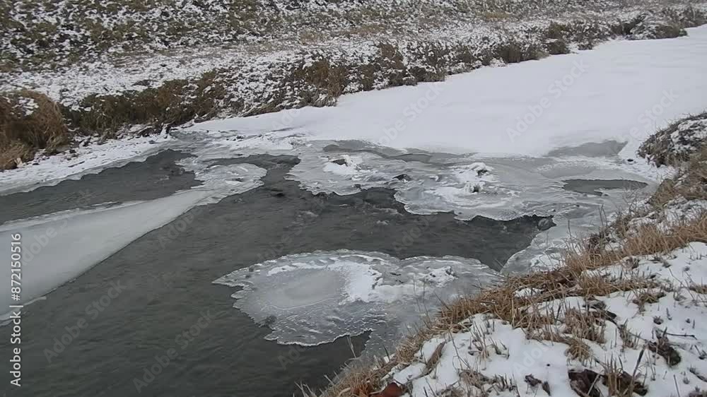 Frozen river covered with ice and snow and river banks with snow on frosty winter day - real time. Topics: season, frost, natural environment, freezing, river current, climate, weather, nature Frozen river covered with ice and snow and river banks with snow on frosty winter day - real time. Topics: season, frost, natural environment, freezing, river current, climate, weather, nature