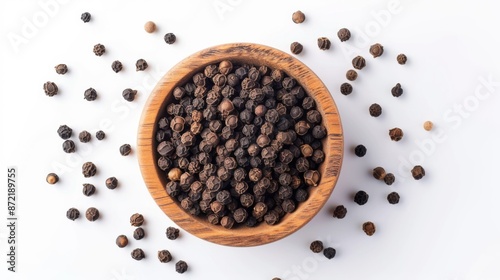 Flat lay of black peppercorns in a wooden bowl on a white background photo