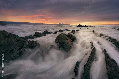 Sunset on Barrika beach, Bizkaia, with the waves entering with force among the flysch photo