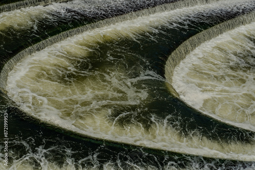White water bubbles over the weir on the Avon River below the Pulteney Bridge.