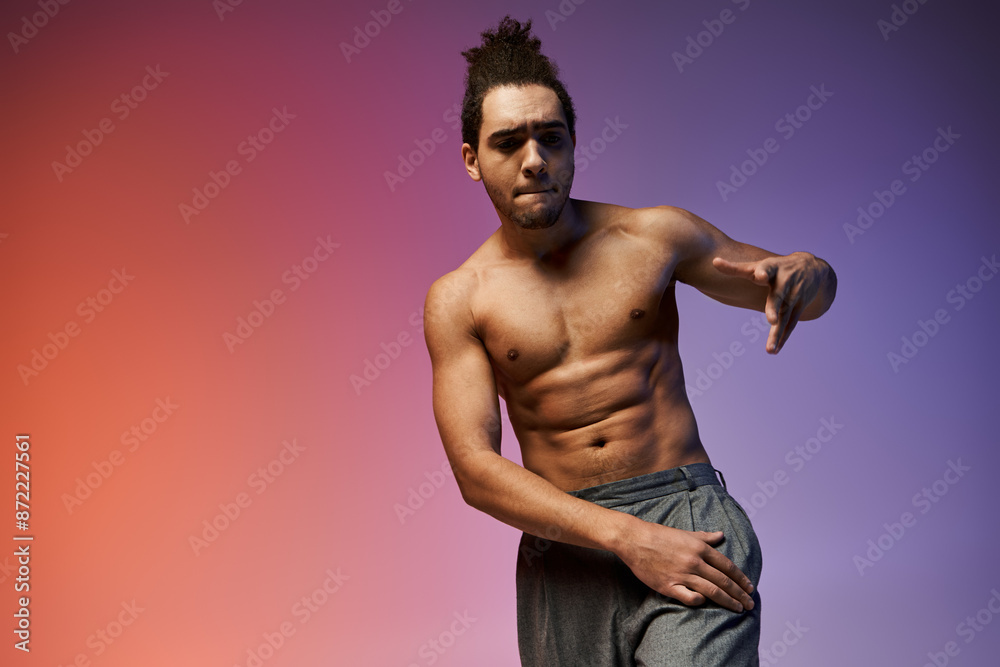Fototapeta premium A young African American man dances against a vibrant, colorful gradient background.