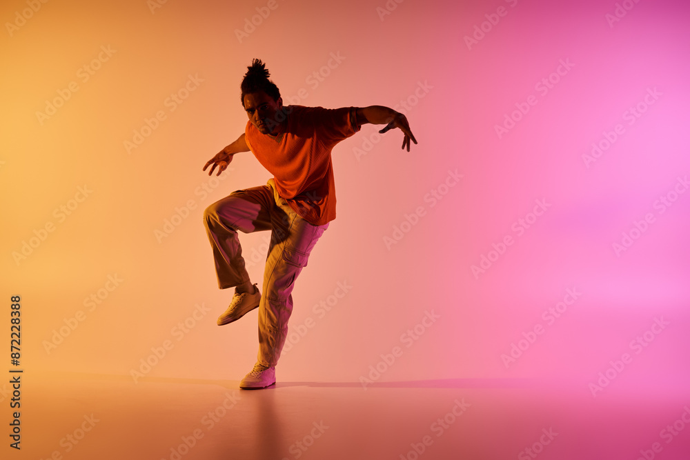 A young African American man dances in front of a colorful gradient background, showcasing his impressive skills and passion. A young African American man dances in front of a colorful gradient background, showcasing his impressive skills and passion.