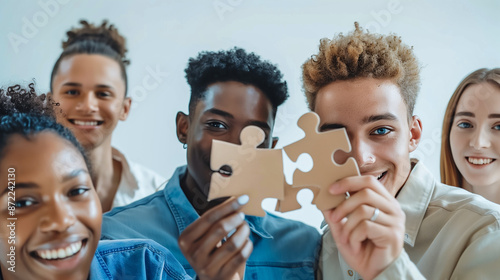 A cohesive team of young men and women holding puzzle pieces. A symbol of team building.