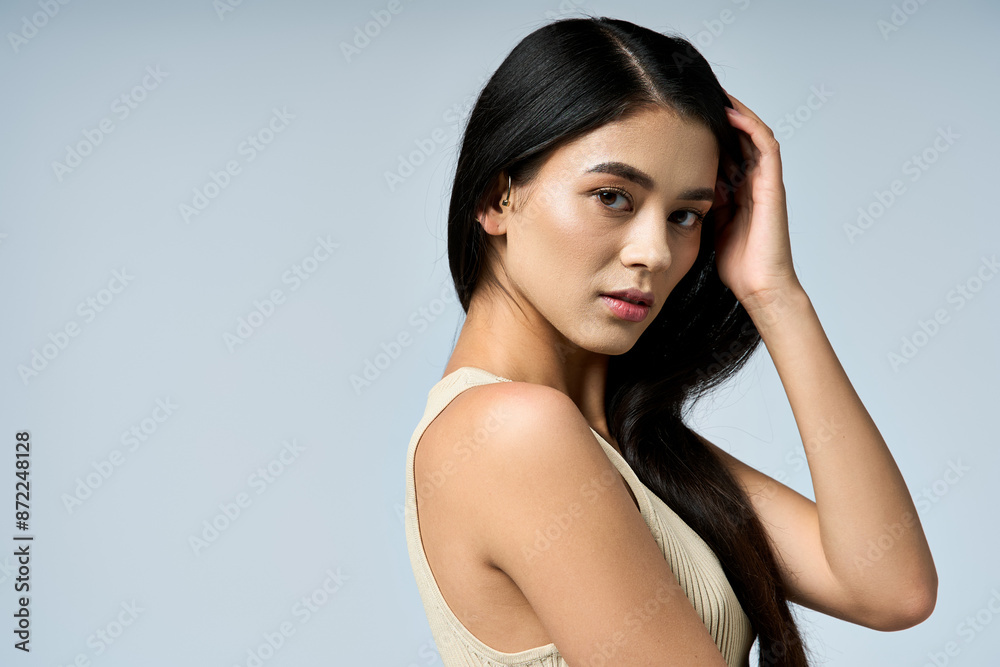 Woman with black hair poses against blue backdrop, captivating viewer. Woman with black hair poses against blue backdrop, captivating viewer.