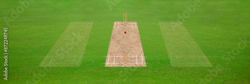 A cricket pitch direct top view of the layout with the grass cricket field. The pitch is inside the field and green field with 2 sides stumps, Cricket match between two teams.
