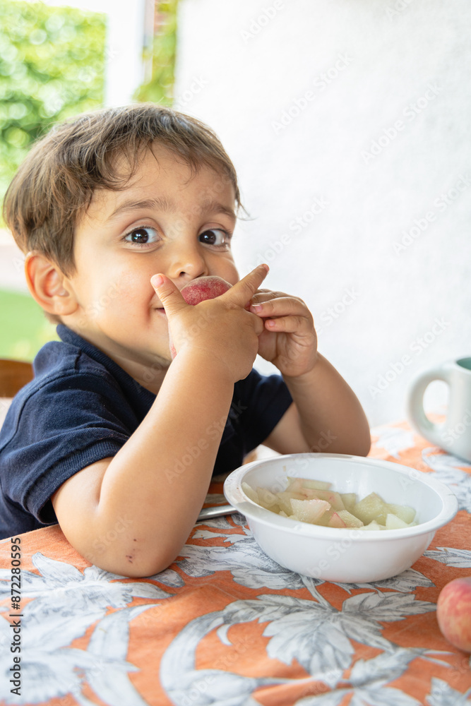 Curious Child Reaching for Fresh Peaches at Table Curious Child Reaching for Fresh Peaches at Table