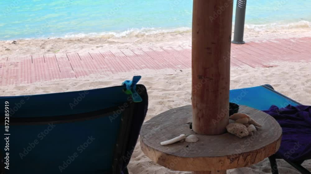 Close-up view of lounge chairs with towels pinned with bird-shaped clips on sandy beach Caribbean Sea. Close-up view of lounge chairs with towels pinned with bird-shaped clips on sandy beach Caribbean Sea.