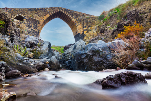 Ponte dei Saraceni. An ancient medieval bridge of Norman age located on the Simeto river. Adrano - Catania, in Sicily. Long exposure picture photo