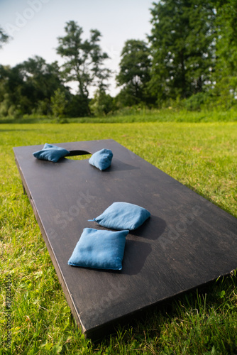 Cornhole board on a green lawn