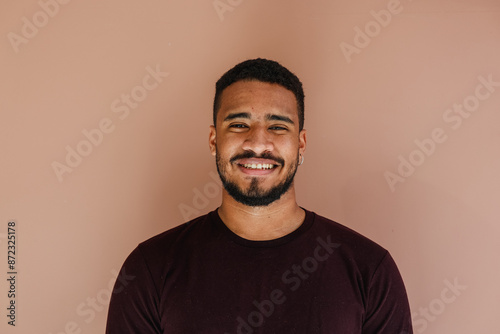 Male portrait of young latin (african american) adult looking at camera with a natural smile