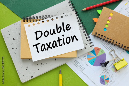 DOUBLE TAXATION, business concept. green background and notepads on financial blocks. text on page
