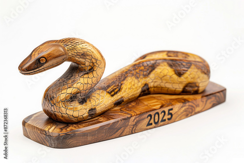 Decorative wooden figurine of a snake on a stand with the inscription 2025, isolated on white, symbol of the new year photo