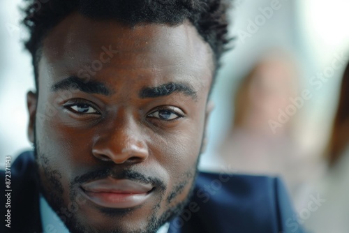 A confident professional in a suit stares intensely toward the camera in a portrait shot, highlighting his serious and focused nature, perfect for business-themed imagery.