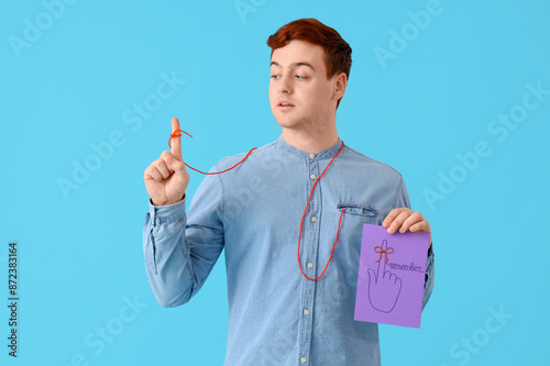 Young man holding paper wit...