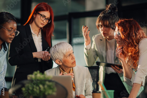 Upset senior businesswoman criticizing her interracial team at office.