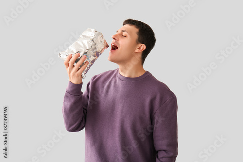 Young man eating potato chi...