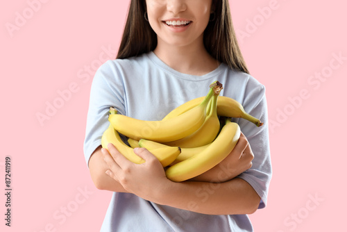 Young woman with bananas on...