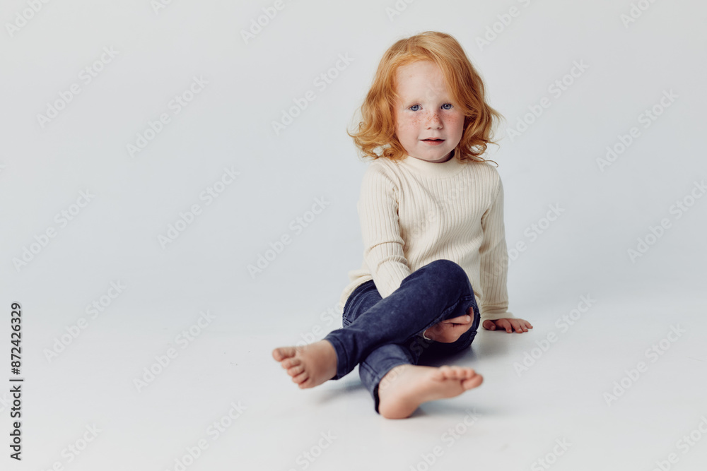 Redhaired girl sitting on floor with hands on knees in relaxation pose for beauty and wellness concept