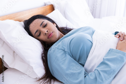 Sleeping peacefully under white blanket, woman resting in bed