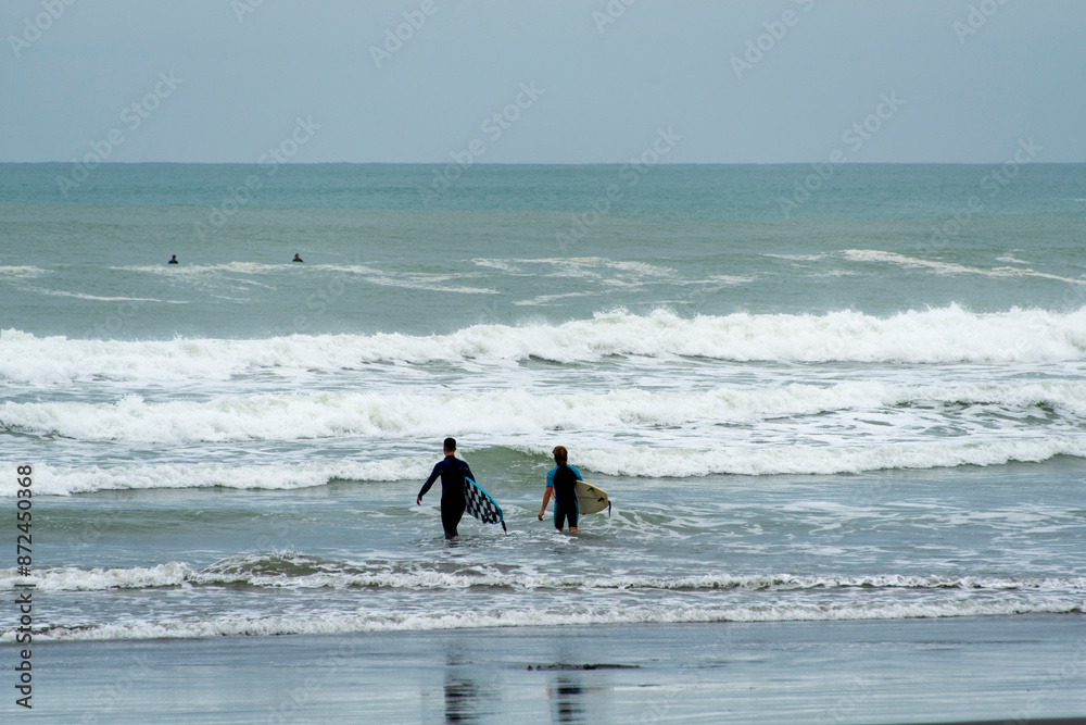 Surfer at Muriwai Gannet Colony Beach - New Zealand Surfer at Muriwai Gannet Colony Beach - New Zealand